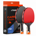 Stiga Carb table tennis set including two paddles with red and black rubber, wooden handles, a blue towel, and the retail packaging box.